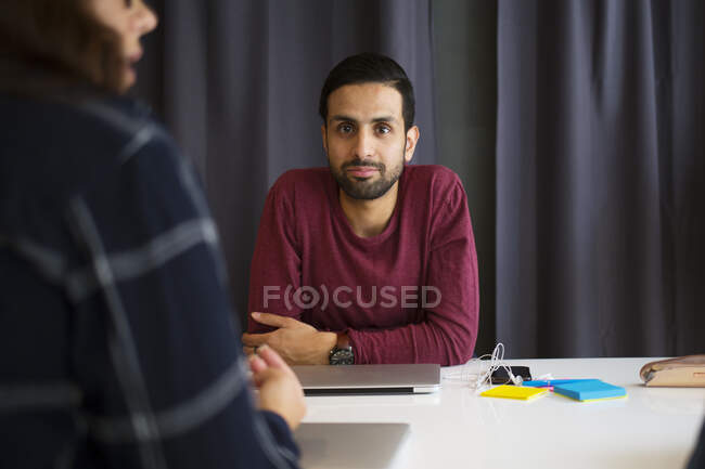 Portrait of young man sitting at conference table — Stock Photo