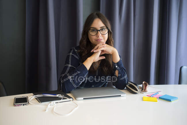 Jovem mulher sentada na mesa de conferência do escritório — Fotografia de Stock