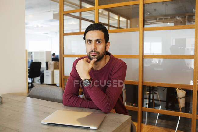 Hombre sentado en la mesa en la oficina - foto de stock