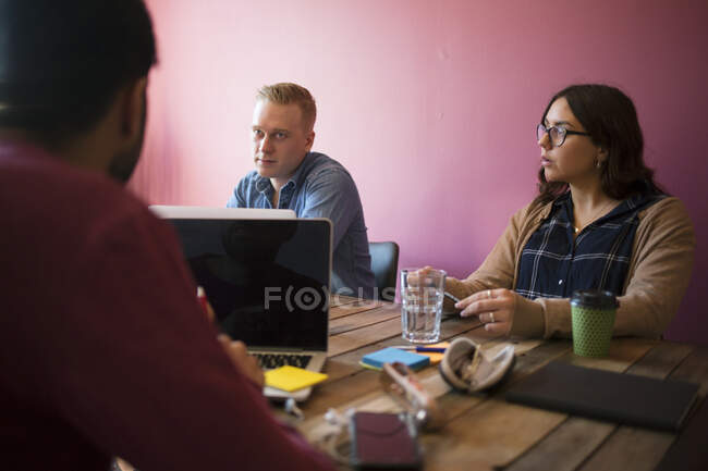 Colaboradores en la mesa durante la reunión de oficina - foto de stock