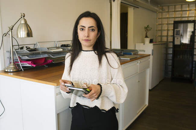 Молода жінка тримає блокнот в офісі — стокове фото