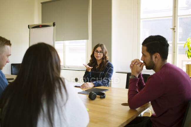 Coworkers sitting at meeting table in office — Stock Photo