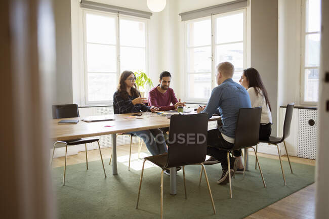 Співробітники, які сидять за столом зустрічей в офісі — стокове фото
