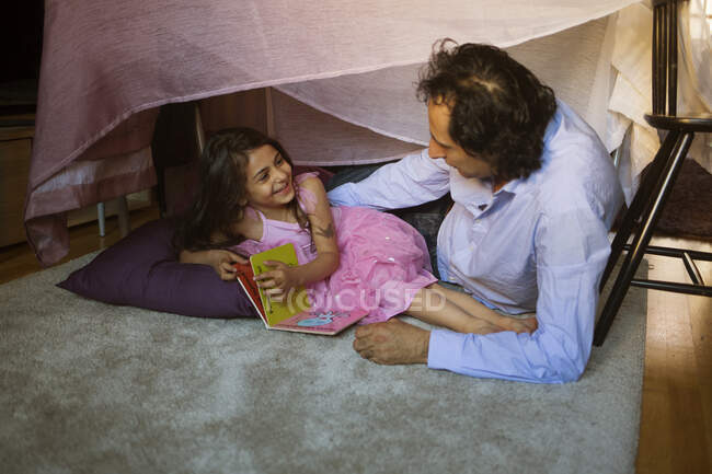 Чоловік з дочкою у форті ковдр — стокове фото