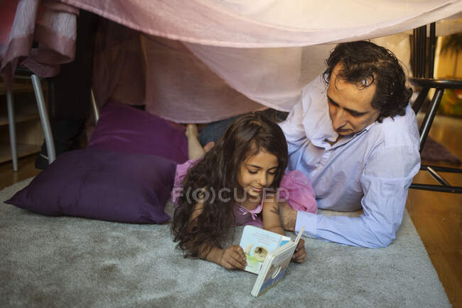 Homem com sua filha no forte cobertor — Fotografia de Stock