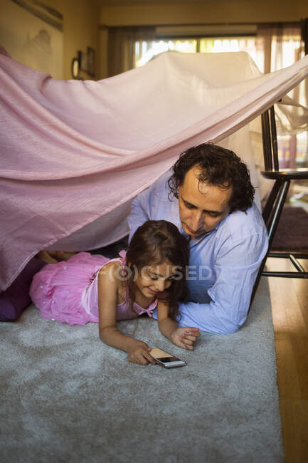 Man with his daughter in blanket fort — Stock Photo