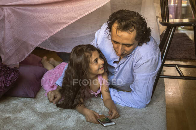 Homem com sua filha no forte cobertor — Fotografia de Stock