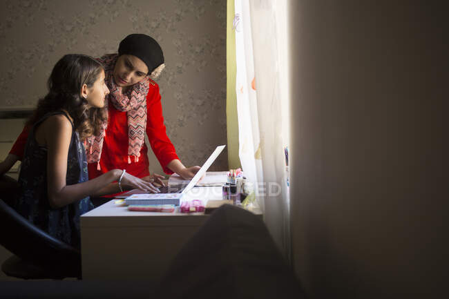 Жінка допомагає доньці вчитися — стокове фото