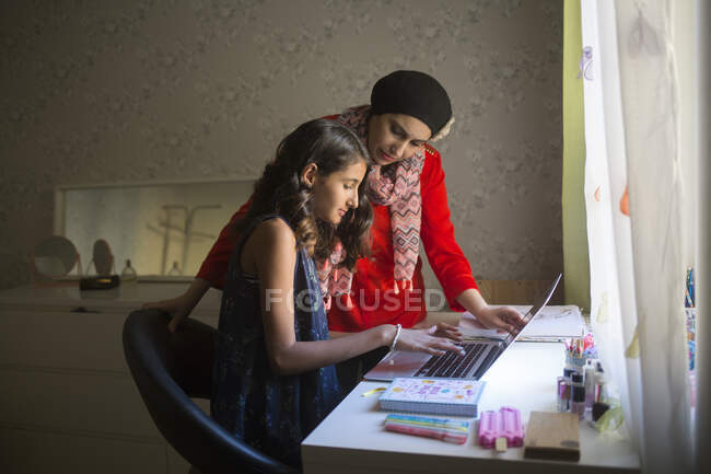 Женщина помогает дочери учиться — стоковое фото