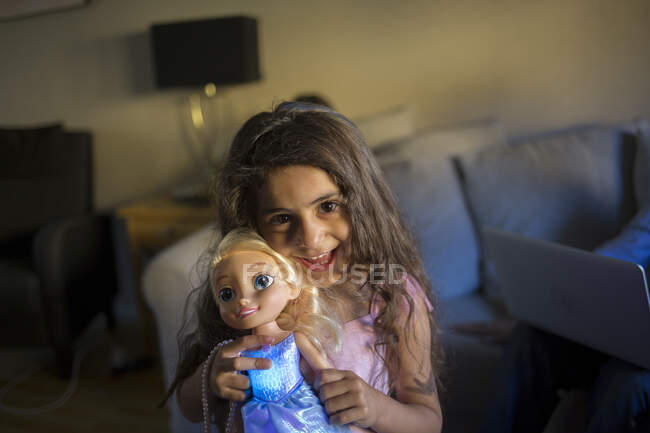 Усміхнена дівчина тримає свою ляльку — стокове фото