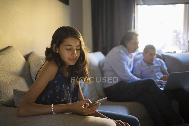 Девушка сидит на диване со своей семьей — стоковое фото
