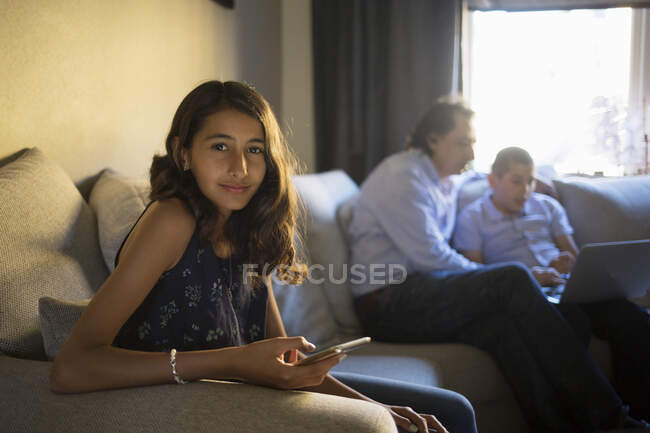 Fille assise sur le canapé avec sa famille — Photo de stock
