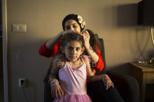Жінка зв'язує волосся своєї дочки в хвіст — стокове фото