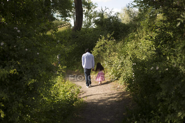 Uomo che cammina con sua figlia nel parco — Foto stock