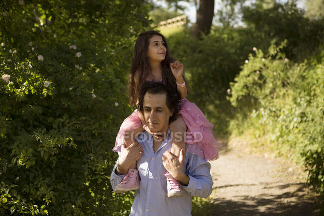 Homem dando filha piggyback passeio no parque — Fotografia de Stock