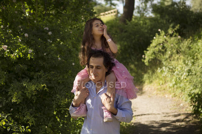 Uomo dando figlia cavalcata a cavallo nel parco — Foto stock