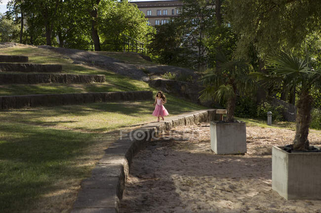 Girl in pink dress playing in park — Stock Photo