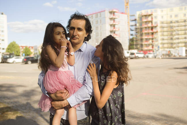 Чоловік з дочками на міській вулиці — стокове фото