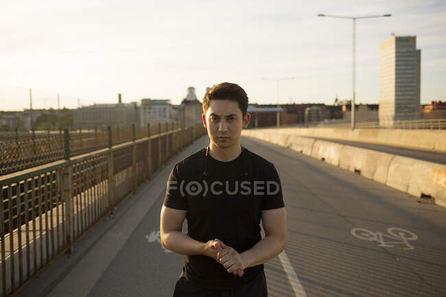 Portrait of young man on bridge — Stock Photo