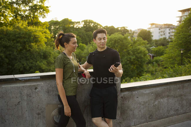 Young man showing woman his smartphone — Stock Photo