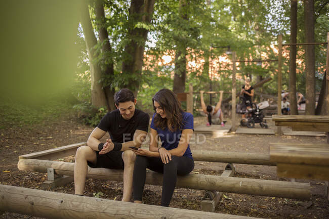 Young woman showing her smartphone to young man — Stock Photo