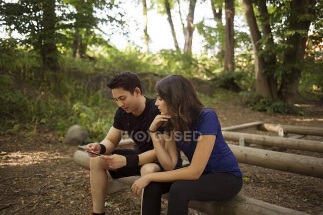 Young man showing her smartphone to young woman — Stock Photo