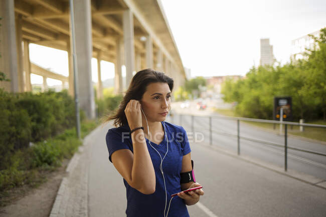 Молода жінка слухає музику в парку — стокове фото