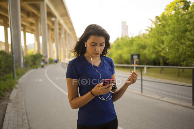 Молода жінка слухає музику в парку — стокове фото