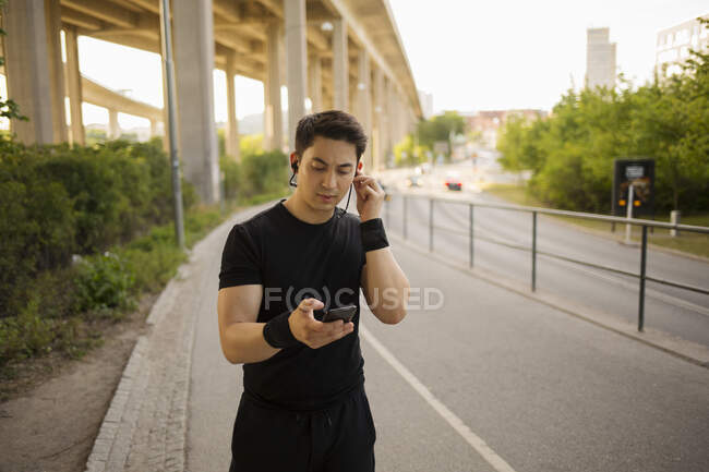 Молодий чоловік слухає музику в парку — стокове фото