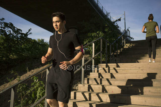 Young man jogging on steps — Stock Photo
