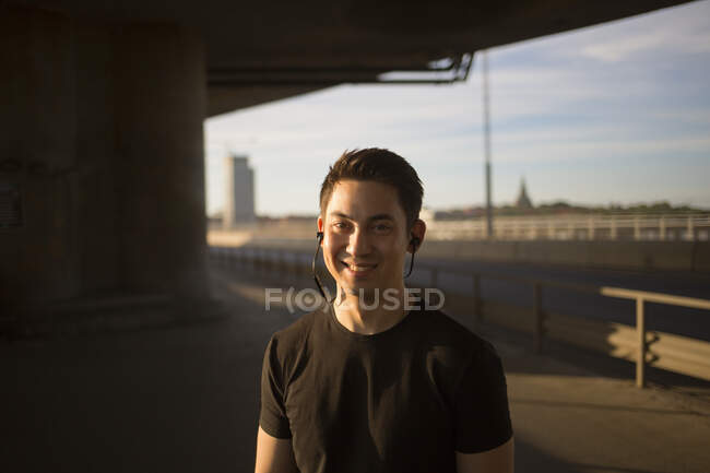 Smiling young man listening to music — Stock Photo