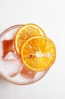 Bevanda rinfrescante decorata con fette di arancia su bianco — Foto stock