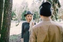 Stylish young woman with blonde dreadlocks looking at boyfriend in park — Stock Photo