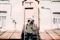 Stylish young couple hugging in front of building facade — Stock Photo