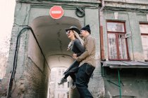 Stilvoller junger Mann trägt Freundin mit Dreadlocks auf der Straße — Stockfoto