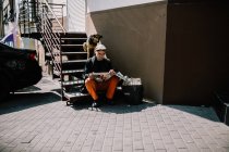 Kiev, Ucrania- 13 de marzo de 2018: Hombre sin hogar sentado en las escaleras y leyendo el periódico - foto de stock