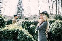 Молода жінка з дредлоками з чоловіком позує в живоплоті в парку — стокове фото