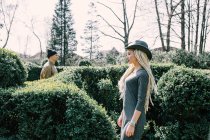 Молода жінка з дредлоками з чоловіком позує в живоплоті в парку — стокове фото