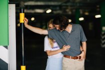 Ragazza bionda abbracciare fidanzato da dietro al parcheggio del centro commerciale — Foto stock