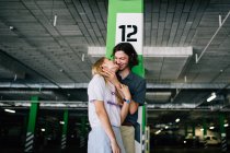 Couple riant embrassant au parking — Photo de stock