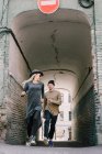 Casal jovem alegremente correndo em archway — Fotografia de Stock