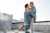 Giovane coppia adulta che abbraccia sulla strada della città contro il cielo — Foto stock