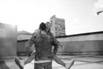 Giovane coppia adulta scherzare sulla strada della città, in bianco e nero — Foto stock