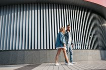 Jeune couple adulte portant des vêtements décontractés se promenant à l'extérieur — Photo de stock