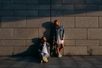 Jeune couple adulte en vêtements décontractés près du mur gris — Photo de stock