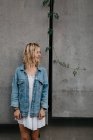 Jovem mulher adulta em roupas casuais contra a parede cinza — Fotografia de Stock