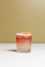 Vue rapprochée d'un cocktail alcoolisé avec des tranches d'orange séchées sur la table — Photo de stock