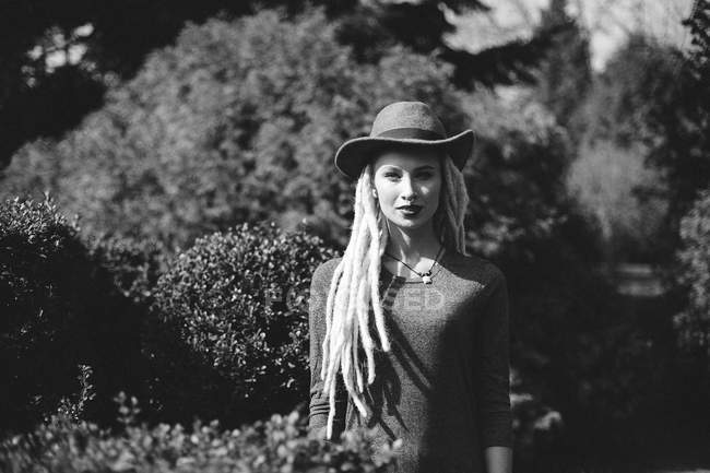 Портрет стильной женщины с дредами в шляпе в парке — стоковое фото