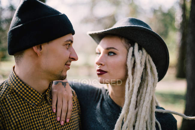 Stylish young woman with blonde dreadlocks leaning on boyfriend shoulder — Stock Photo