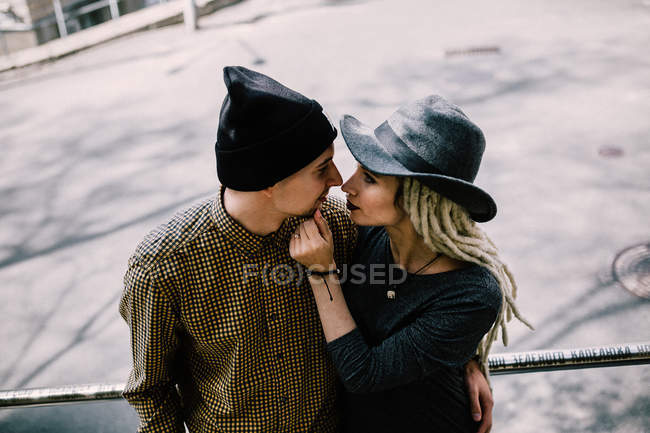 Elegante pareja joven abrazándose en la calle de la ciudad - foto de stock